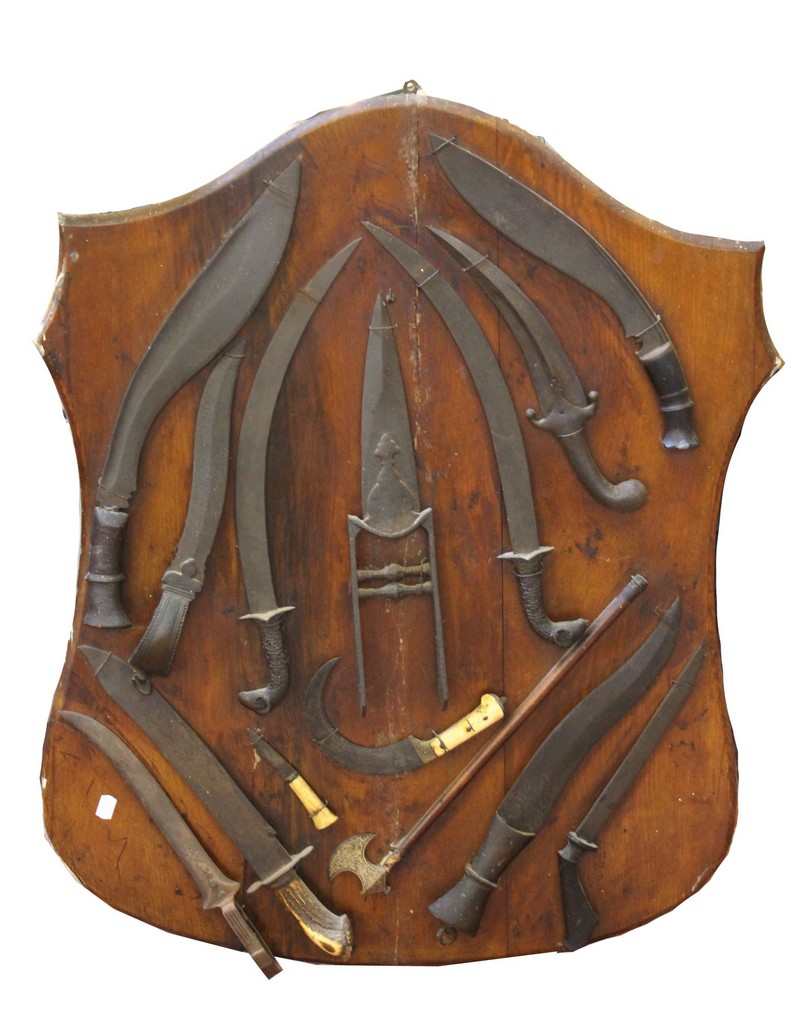 An oak shield, mounted with various Indian and Indian Sub-Continent edged weapons.