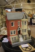 A Victorian style doll`s house, with pitched roof and a selection of furniture, 69cm wide,112cm