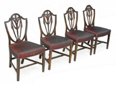 A set of four mahogany chairs, in George III style each with wheatsheaf pierced splat and padded