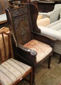 A 17th Century style carved oak wing armchair with a lozenge carved back  Best Bid