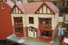 A 1930`s style doll`s house, with double bay windows and a selection of furniture, 86cm wide, 64cm