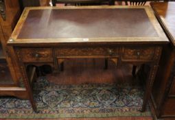 An Edwardian rosewood and marquetry writing table, with three drawers 100cm wide