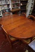 A cherrywood extending circular table with six rush seat chairs 182cm length