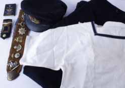 A Collection of World War II Regimental badges, a cap with an HMS Drake ribbon, Navy tunic and