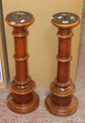 A pair of turned mahogany church candlesticks; 75cm high