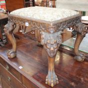 A carved mahogany footstool in the manner of William Kent, with scroll carved frieze, rams head