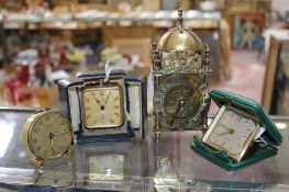 A reproduction miniature carriage clock, three travelling timepieces and a chiming mantel clock