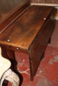 A provincial oak drop leaf table with plank top and cleated ends on square tapering legs 124cm