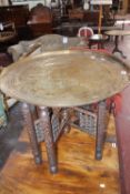 A Middle Eastern engraved brass tray top table 58cm high, 70cm diameter  Best Bid