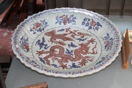 A large oriental style charger with dragon decoration; 71cm diameter