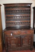 A French provincial carved oak dresser with an arcaded rack above an arrangement of drawers and