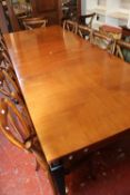 A modern extending mahogany dining table with gilt metal mounted ebonised gilt metal mounted legs