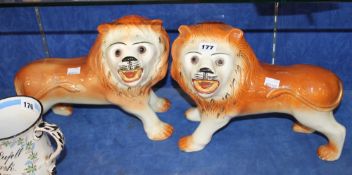 A pair of Staffordshire lions with set glass eyes; 25cm high