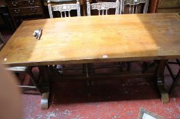 An oak refectory table with shaped supports joined by a central stretcher 191cm extended