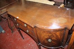 A George III style mahogany sideboard with two drawers flanked by cupboards on square tapering legs