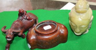 A hardstone Buddha head with associated stand, a carved wooden model of a boy atop of a water