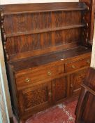 An oak dresser with a platerack and drawers and cupboards below 157cm high, 132cm wide