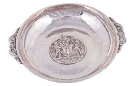 A silver coloured bowl, stamped €0`, with twin foliate scroll handles A silver coloured bowl,