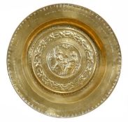 A Nuremberg brass alms dish, late 16th century, with raised rim above the flat edge stamped with