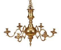 A late George II brass six light chandelier, circa 1755-60, the cylindrical sockets and drip pans on