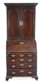 A George II mahogany bureau bookcase, circa 1750, the dentil moulded cornice above a pair of field