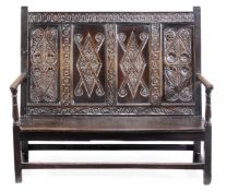 A Charles II oak panel back settle, circa 1660, Yorkshire, the rectangular back with entwined link