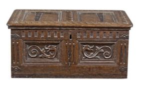 A Charles II oak desk box, circa 1660, the twin panelled hinged lid with guilloche carved borders