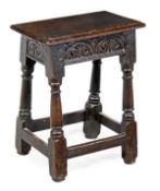 A Charles I oak joint stool, circa 1630, the solid rectangular seat with moulded edge above a