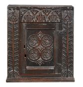 A Charles I oak mural cupboard, circa 1630, Gloucestershire, the acanthus and lunette carved