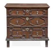 A Charles II oak chest of drawers, circa 1660, the rectangular top above three mitre panelled