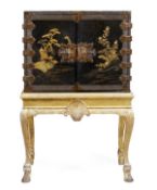A black lacquer and parcel gilt cabinet on stand, the cabinet late 17th/early 18th century, the