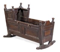 A William III oak child’s cradle, circa 1695, of rectangular tapering form and of fielded panel