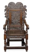 A Charles II oak panel back armchair, circa 1660, Leeds, Yorkshire, the cartouche shaped back carved