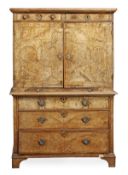 A George I walnut and featherbanded cabinet on chest, circa 1720, the frieze drawer above a pair