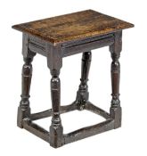 A Charles I oak joint stool, circa 1630, the solid rectangular seat with moulded edge above a