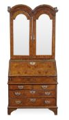 A George II walnut double dome bureau bookcase, circa 1740, the moulded cornice above a pair of