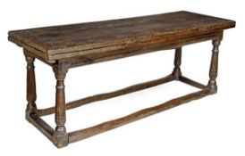 A James I oak draw leaf table, circa 1600, the rectangular cleated triple plank top with single draw