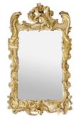 A George III carved giltwood wall mirror, circa 1760, the shaped rectangular plate within a