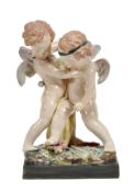 A large Staffordshire pearlware group of two wrestling putti, circa 1825, on a flower-encrusted