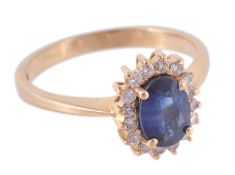 A sapphire and diamond cluster ring, the oval cut sapphire claw set within a... A sapphire and