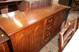 A cherrywood sideboard with arched panelled twin doors flanking for central drawers 84cm high,