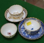 A Caughley tea bowl and saucer decorated with a blue temple pattern and additional gilding,