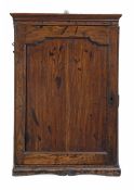 A George III oak hanging cupboard, circa 1780, the moulded cornice above a panelled cupnoard door