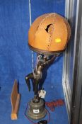 An Art Deco table lamp modelled as a partially nude dancer holding a shade, set upon a column base;