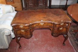 An early 20th Century walnut writing table with tooled writing surface and five drawers on cabriole
