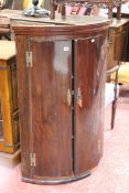 A 19th Century mahogany bow front corner cabinet enclosing shelves  Best Bid