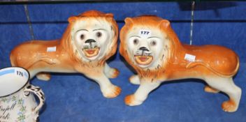 A pair of Staffordshire lions with set glass eyes; 25cm high