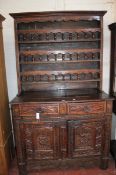 A French provincial carved oak dresser, 19th century with an arcaded rack above an arrangement of