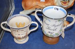 Two twin handled pottery frog mugs held on pedestal bases; the larger 18.5cm high