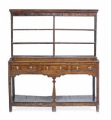 A George III oak dresser, circa 1780, with an open plate rack with metal hooks. the base with three